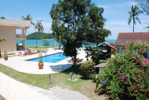 a villa with a pool and a view of the ocean at Frangipani Langkawi Resort in Pantai Cenang
