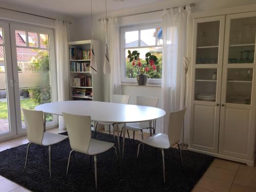 a dining room with a white table and chairs at Meeresbrise in Graal-Müritz