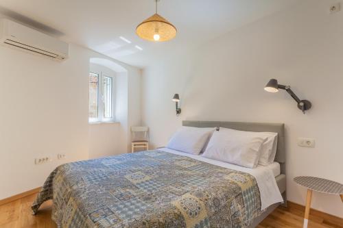 a bedroom with a bed in a white room at Casa Tonina in Cres