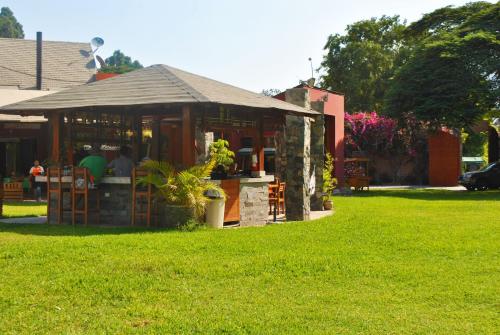 a building in a yard with a green lawn at Huertalejandro Restaurante Campestre y Hospedaje in Cieneguilla