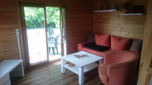 ein Wohnzimmer mit einem roten Sofa und einem Tisch in der Unterkunft Sann/ Michaelis in Waren (Müritz)