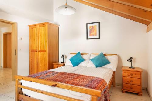 ein Schlafzimmer mit einem Bett mit blauen Kissen in der Unterkunft Hafod a Hendre in Lauterbrunnen