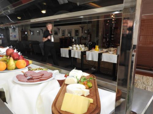a restaurant with a table with cheese and food on it at Hill View Hotel Apartments in Pissouri