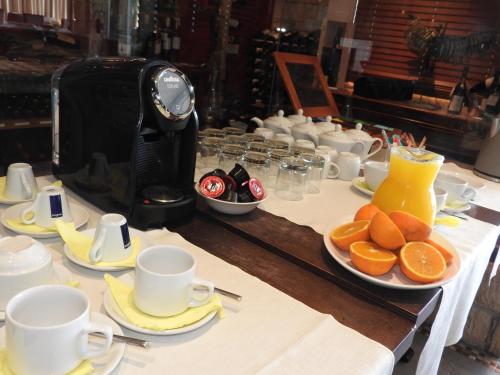 a table with cups and plates of oranges on it at Hill View Hotel Apartments in Pissouri