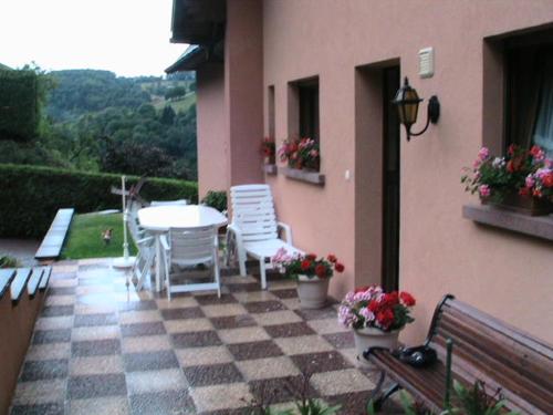 a patio with a table and chairs on a checkered floor at GITE CHEZ SYLVIE in Fréland