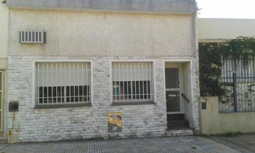 un edificio de ladrillo con ventanas con barrido y una puerta en Casa habitacion en Pergamino