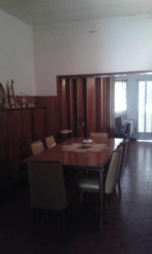 comedor con mesa de madera y sillas en Casa habitacion en Pergamino