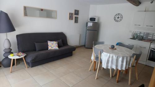 uma sala de estar com um sofá e uma mesa em Appartement Duplex em Bretenoux