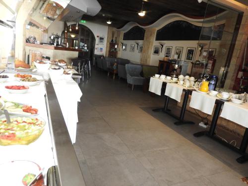 a restaurant with white tables with food on them at Hill View Hotel Apartments in Pissouri