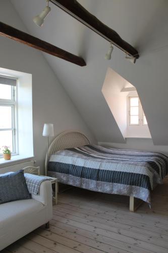 KokkedalにあるKildegaardenのベッドルーム1室(ベッド1台、屋根裏部屋のソファ付)