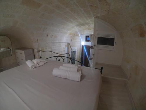 a bedroom with a white bed with towels on it at casa principe di napoli in Polignano a Mare
