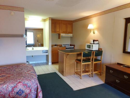 a hotel room with a bed and a kitchen at Executive Inn Yanceyville in Yanceyville