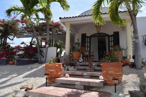 une petite maison avec des palmiers et une véranda dans l'établissement Casa Bonita Inn, à La Parguera