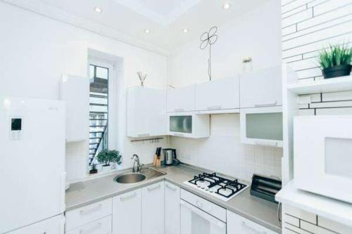 a white kitchen with white cabinets and a sink at Apartments in Uzhgorod in Uzhhorod