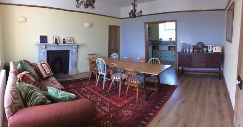 a living room with a table and chairs and a couch at Treganoon House, Lanlivery in Bodmin