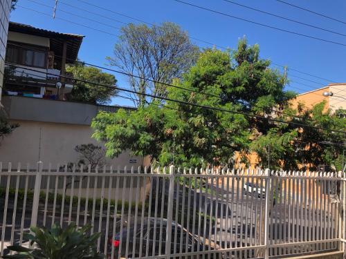 uma cerca branca em frente a uma casa em Bilingual Home em Belo Horizonte