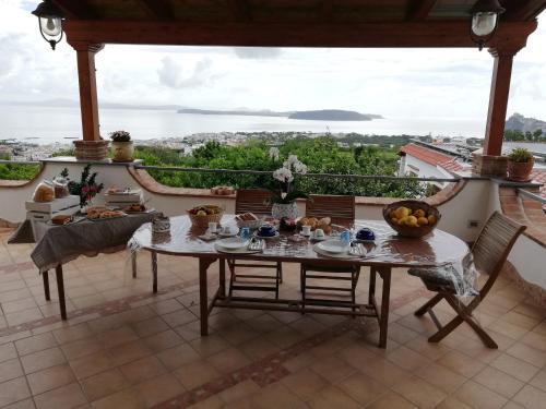 a table and chairs on a balcony with a view at Relais Maison de Charles in Ischia