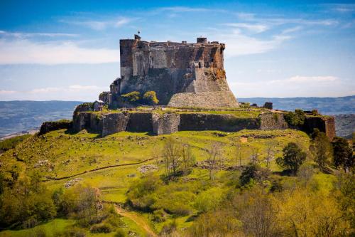 an old castle on top of a hill at La Dormeuse du Val in Chambon-sur-Lac
