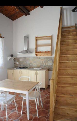 a kitchen with a wooden table and a staircase at DONNA FELICIA in Pachino
