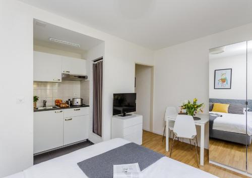 a kitchen and a bedroom with a bed and a table at Rent a Home Delsbergerallee - Self Check-In in Basel