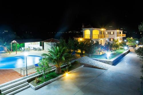 - une vue aérienne sur une maison et une piscine la nuit dans l'établissement Glyfada Villas, à Paralio Astros