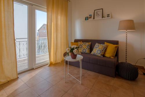 ein Wohnzimmer mit einem Sofa und einem Tisch mit Blumen in der Unterkunft Apartmani Čvorak in Vodice