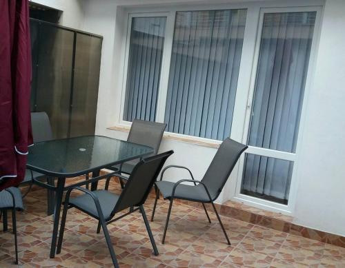 a glass table and chairs in a room with windows at STUDIO SUNRISE in Varna City