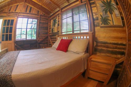 ein Schlafzimmer mit einem Bett in einer Holzhütte in der Unterkunft Log 33 in Ocho Rios