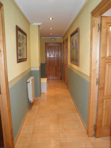 a hallway with green and yellow walls and wooden doors at Apartamento Casa Geli #1 in La Robellada de Onis