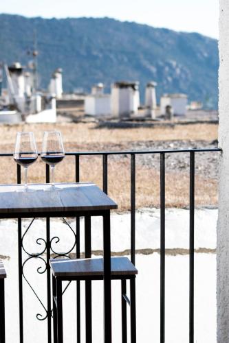 two glasses of wine sitting on a table on a balcony at Apartamentos Vista Veleta in Capileira