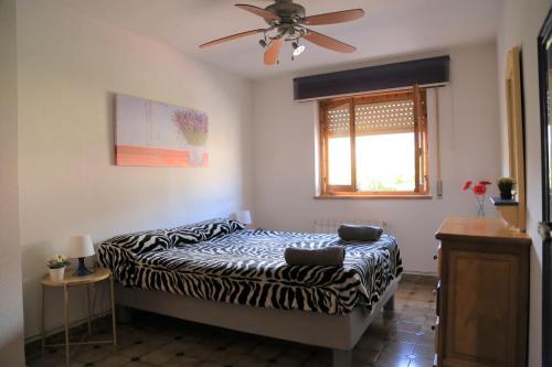 ラ・アドラダにあるEl Chauroのベッドルーム1室(シマウマプリントのベッド1台、シーリングファン付)