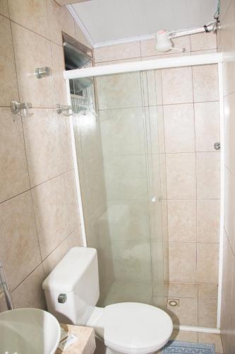 a bathroom with a shower with a toilet and a sink at Hotel Morada do Mar in Guarujá