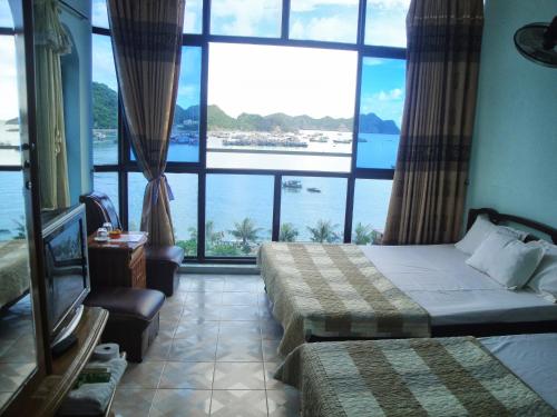 a hotel room with two beds and a large window at Phuong Mai Family Hotel in Cat Ba