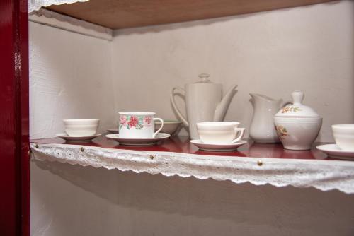 a shelf with tea cups and vases on it at Casa Cueva Salamandra in Pozo Alcón