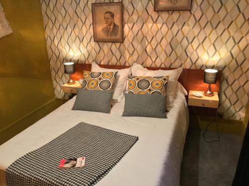 een slaapkamer met een bed met kussens en 2 lampen bij LA RIEUSE POUET-POUET in Mers-les-Bains