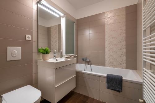 a bathroom with a sink and a tub and a toilet at Studio Q in Fažana