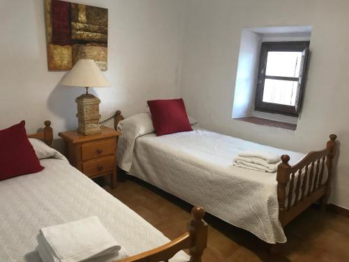 um quarto com 2 camas, um candeeiro e uma janela em Casa Rural Pimentel em Benalauría