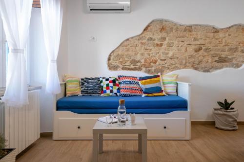 a room with a bed with pillows and a table at Studio Q in Fažana