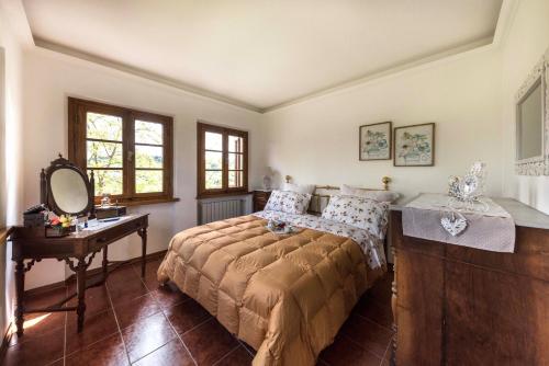 1 dormitorio con cama, mesa y espejo en Casa Ermo Colle, en Sant'Ermo