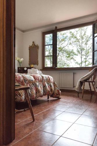 a bedroom with a bed and a large window at Casa Ermo Colle in Sant'Ermo