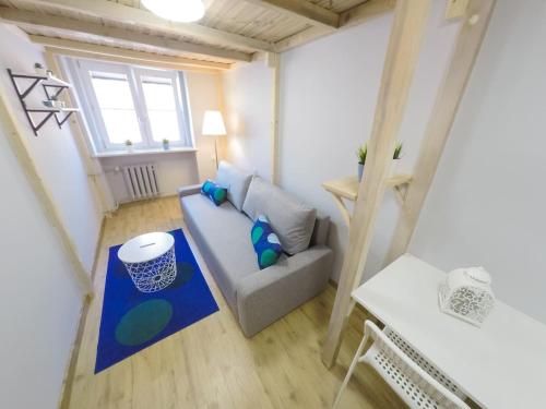 una pequeña sala de estar con sofá y ventana en Rynek 20/21 -Cosy New Apartment on The Market Square - 4 Bedrooms - 8 People en Breslavia