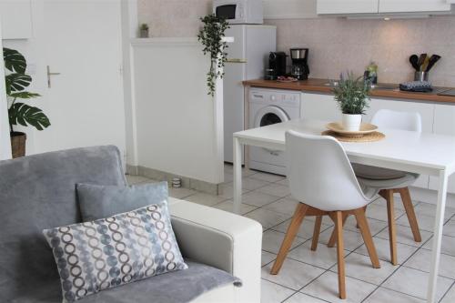 une cuisine avec une table blanche, une chaise blanche et une table dans l'établissement Clos Saint Médard, à Saint-Médard-en-Jalles