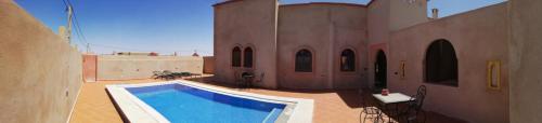 a swimming pool in a courtyard of a building at Riad Dar Poublanc in Merzouga