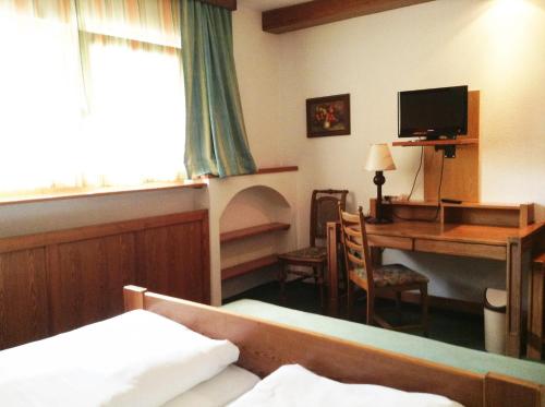 巴特斯哈爾巴赫的住宿－Hotel Grünes Türl，一间卧室配有一张桌子和一张床,一张书桌和一台电脑