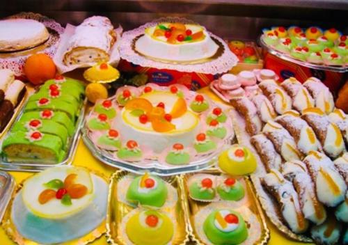 a table with many different types of cakes and pastries at Relax Near The Sea in Noto Marina