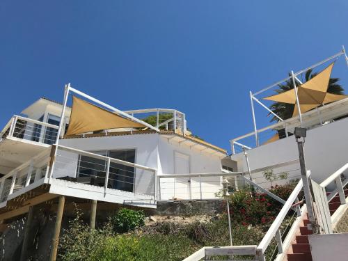 a white house with balconies on the side of it at Muelle Apart Hotel in Tongoy
