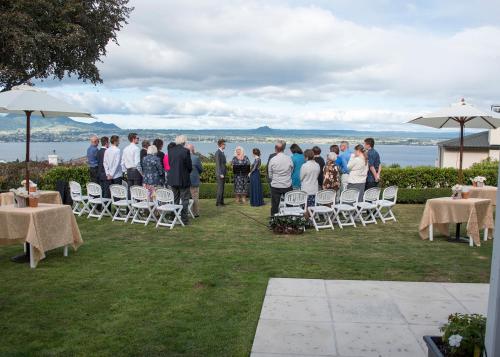 a group of people standing in a lawn with tables and chairs at Bellevue Boutique Lodge in Taupo