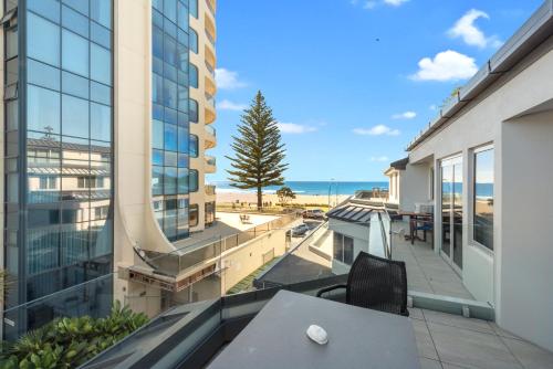 a balcony with a table and a view of the beach at Pavilion Beachfront Apartments in Mount Maunganui