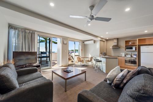 a living room with a couch and a table at Pavilion Beachfront Apartments in Mount Maunganui
