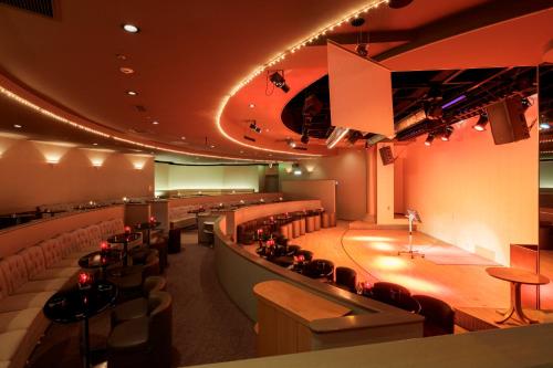 a large room with a bar and some chairs at Hotel Shion in Morioka